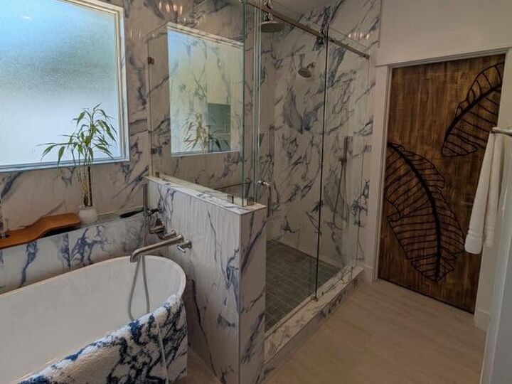 Custom glass enclosure beside a freestanding tub
