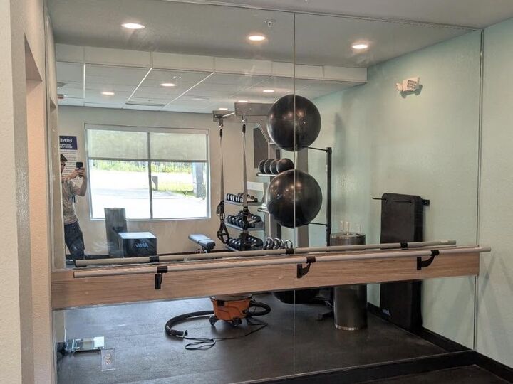 Commercial gym mirror wall installed by Deep South Glass