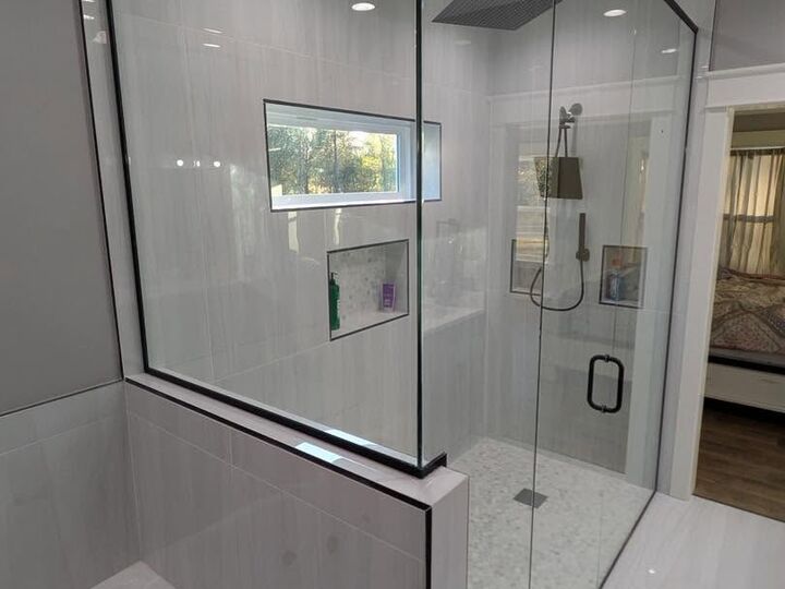 Custom glass shower enclosure over a tiled half wall